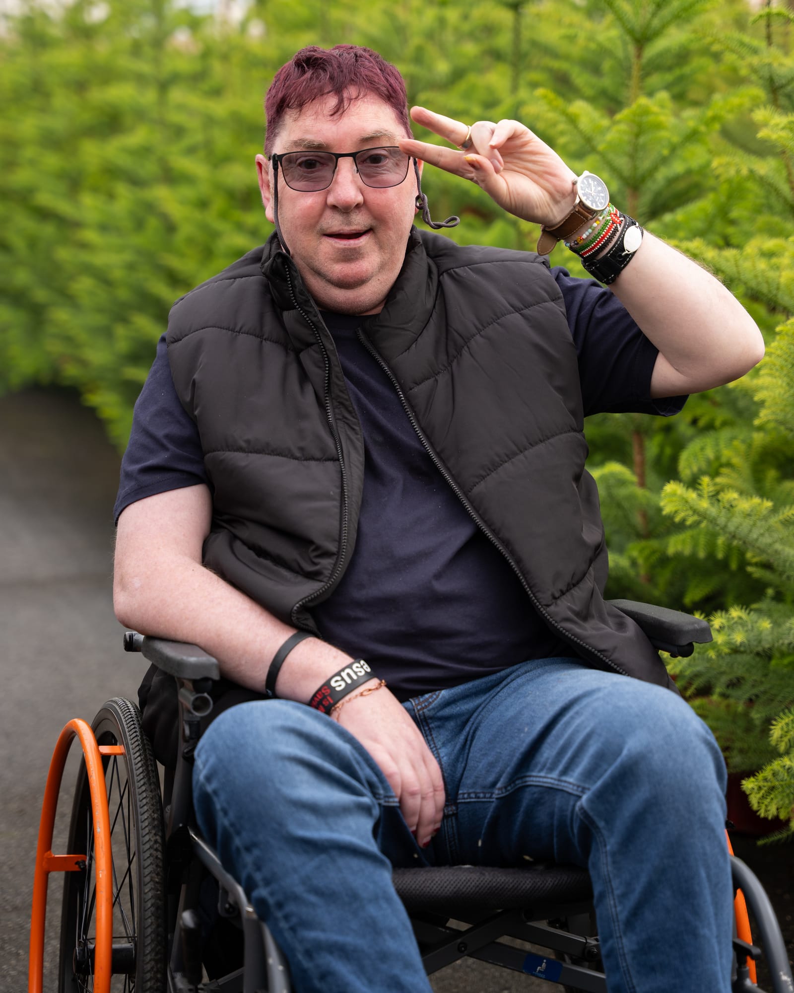 A QB Care participant smiling and waving at a garden nursery